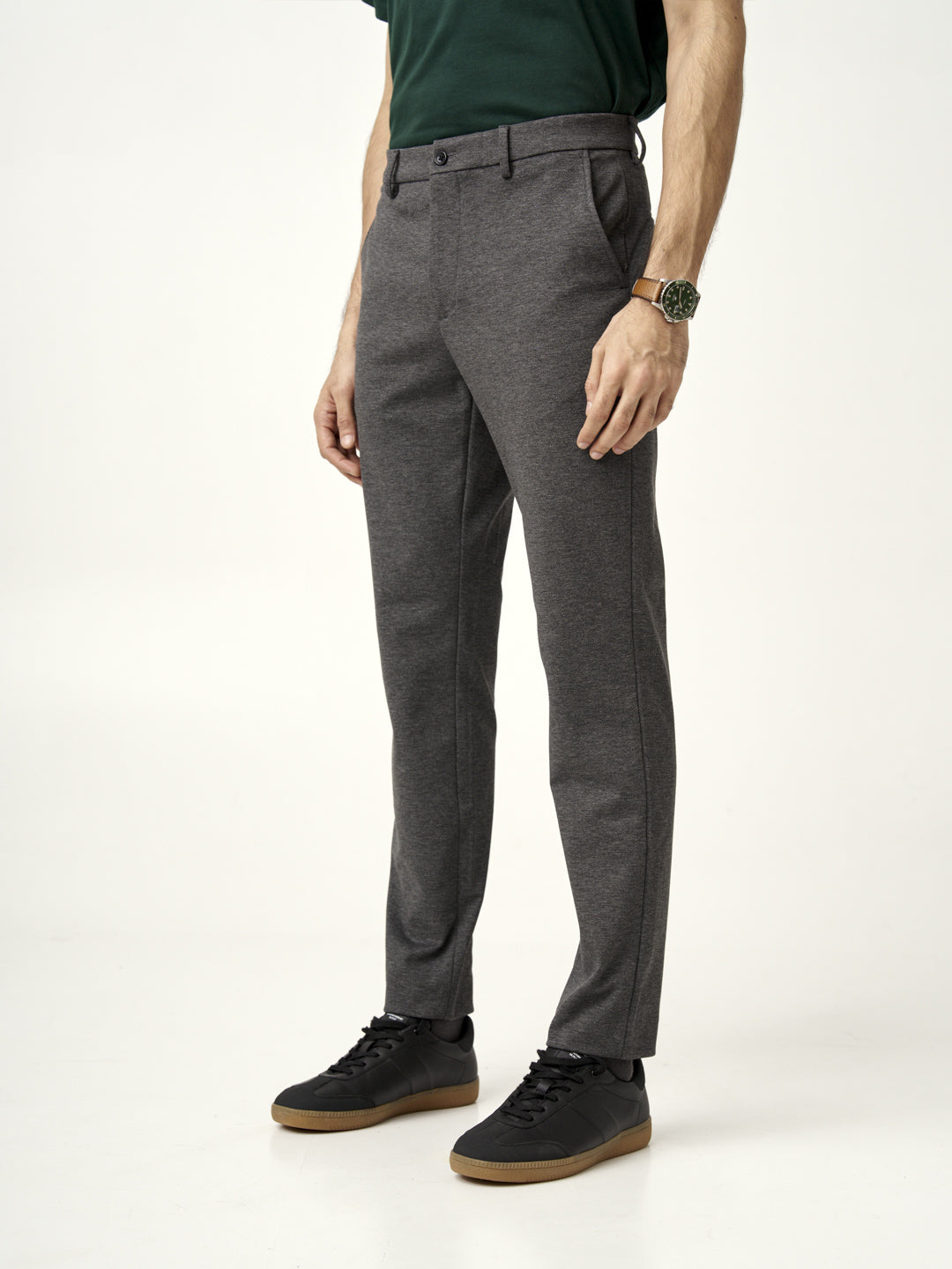 a man in charcoal pants by the Pant Project paired with a green t-shirt and dark jacket