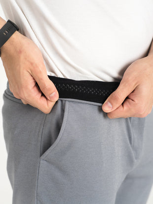 Light grey stretchable trousers by pant project, highlighting the slim fit and soft fabric texture.