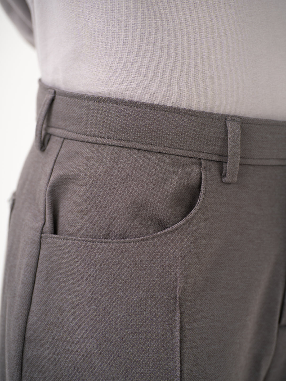 Close-up view of grey pants by Pant Project focusing on the waistband and pocket detailing