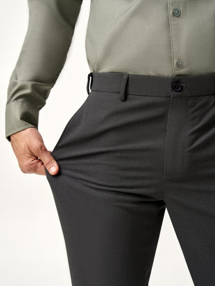 model leaning against wall, full view of Pant Project slate grey trousers