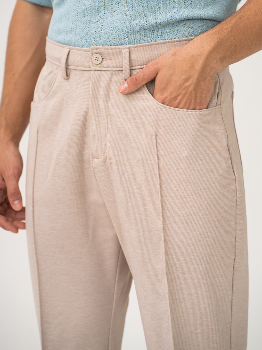 Close-up view of beige pintuck pants by pant project, focusing on the waistband and pocket detail