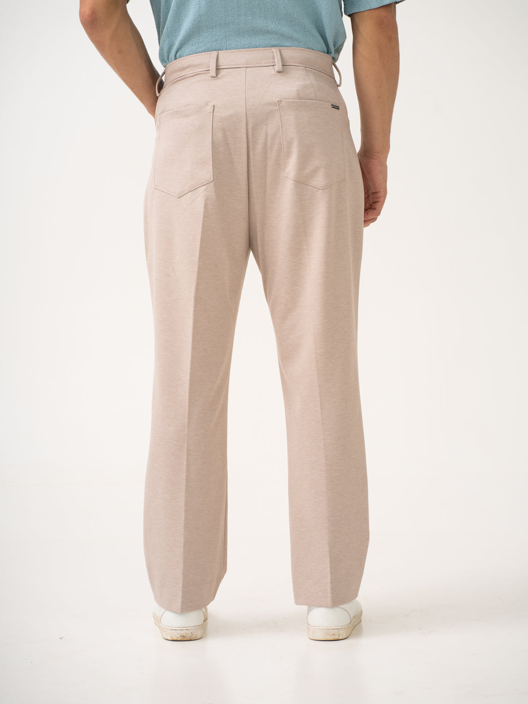 Rear view of beige pintuck pants by pant project, focusing on the back pockets and fit