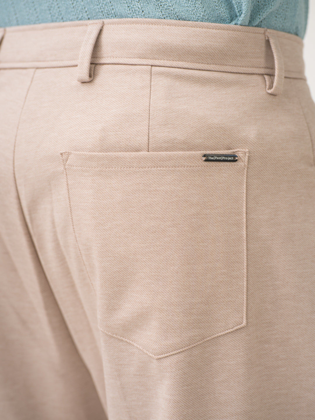 Close-up view of beige pintuck pants by pant project, focusing on the back pocket detail
