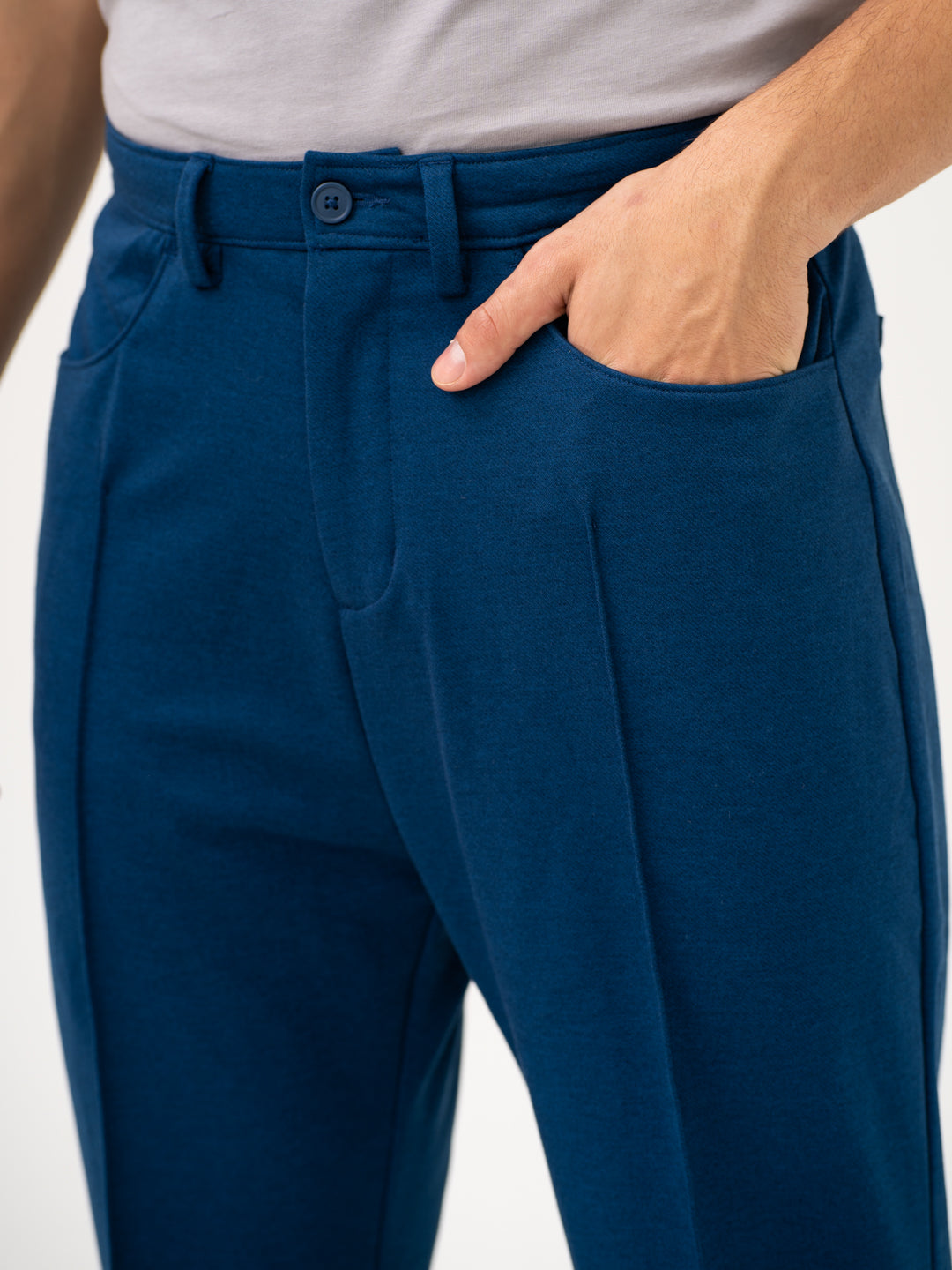 Close-up view of blue pintuck pants by pant project, focusing on the waistband and pocket detail