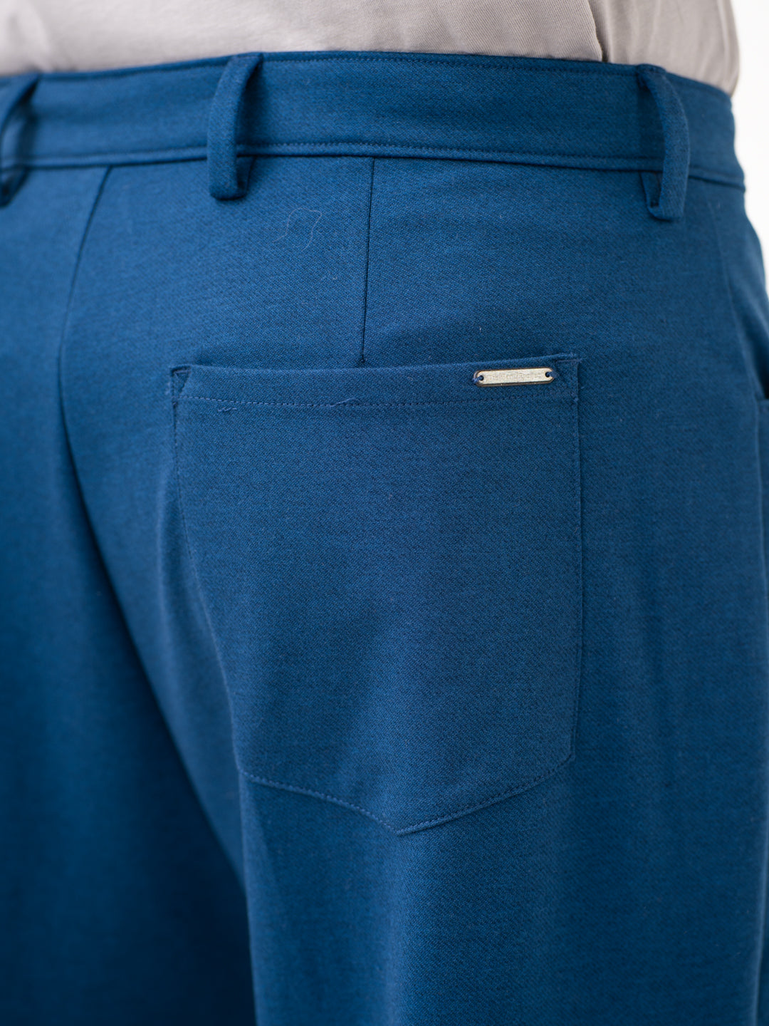 Close-up view of blue pintuck pants by pant project, focusing on the pocket detail