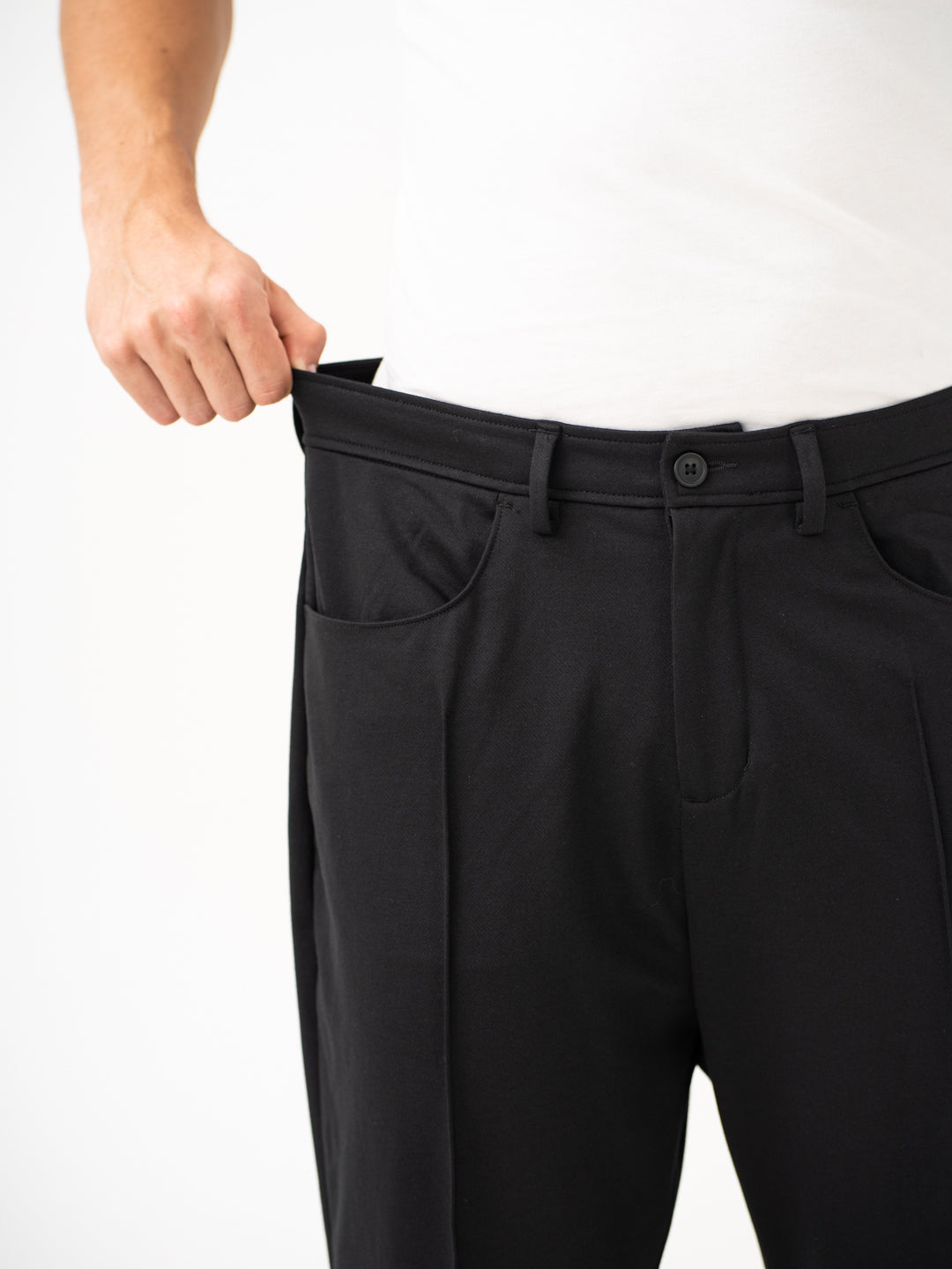 Close-up view of black pintuck pants by pant project, focusing on the stretchable waistband