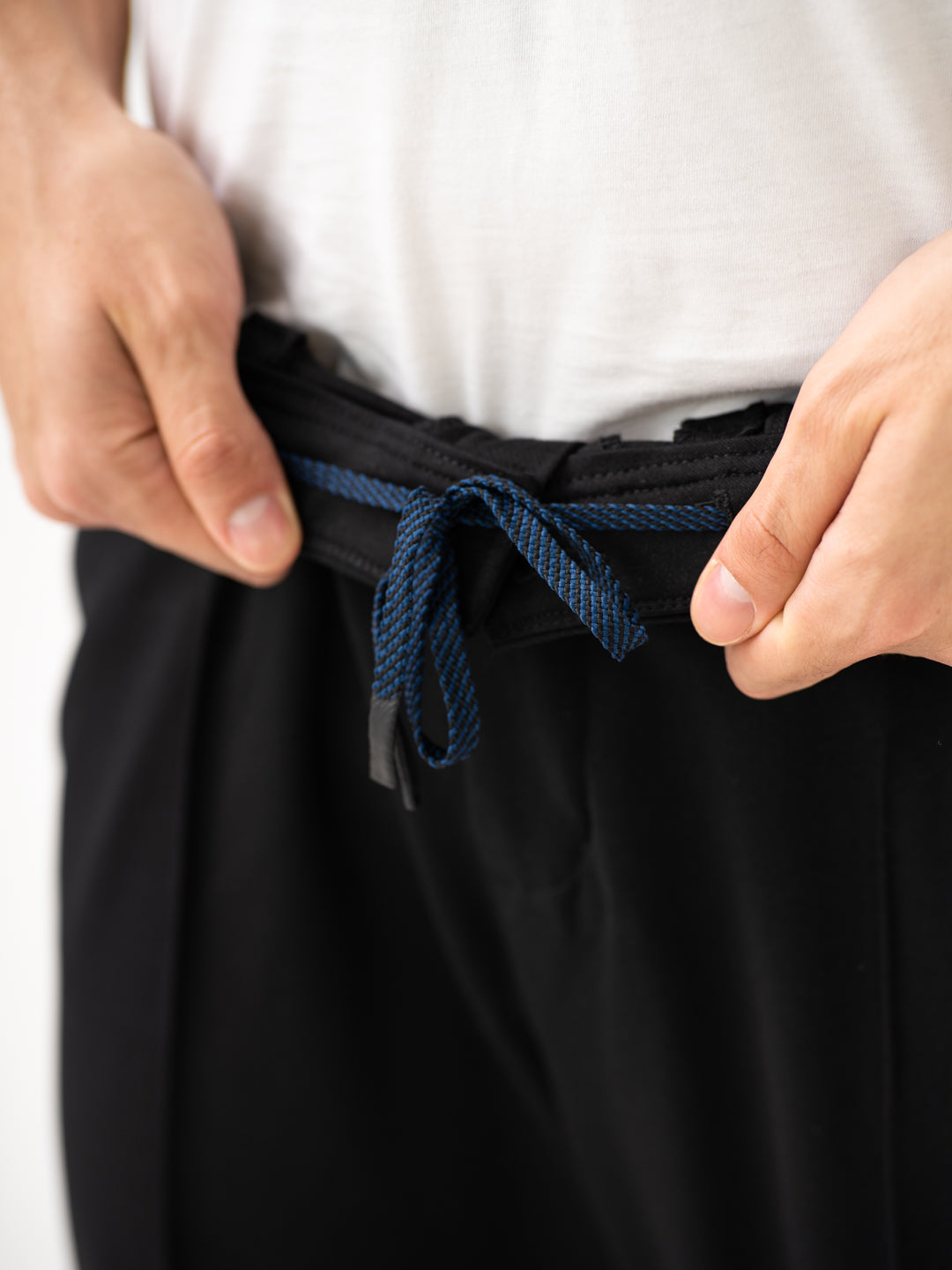 Close-up view of black pintuck pants by pant project, focusing on the waistband and drawstring detail