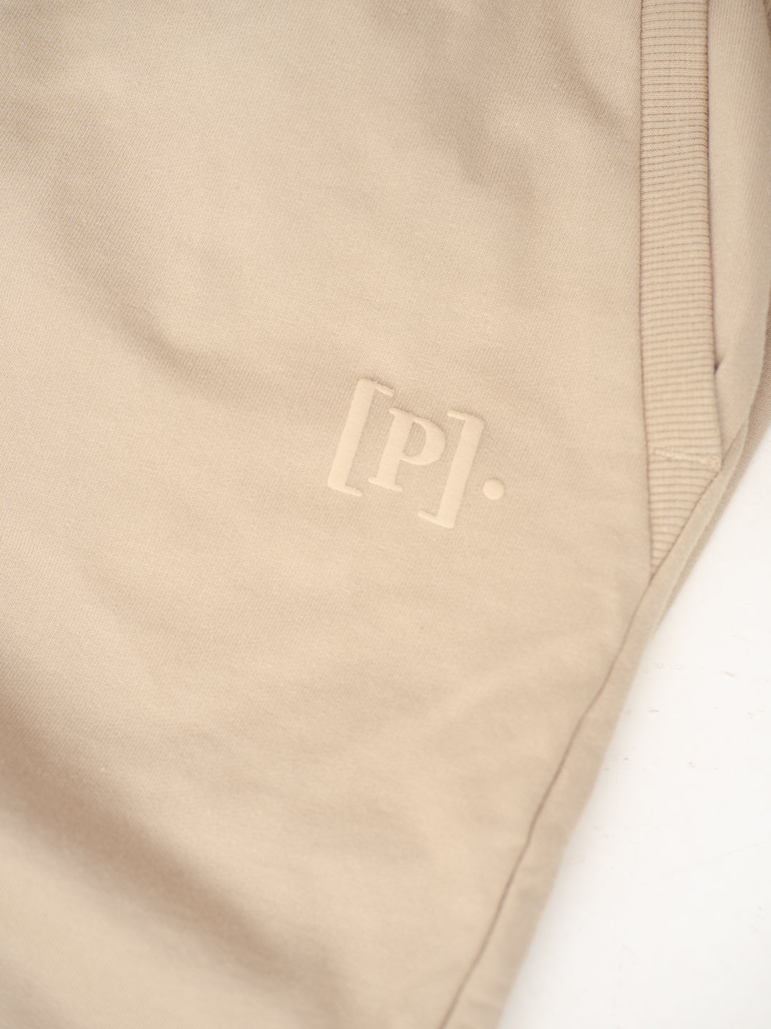 close-up view of nomad beige sweatpant by pant project featuring logo detail