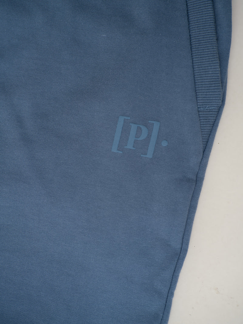 close-up view of pixel blue sweatpant by pant project featuring logo detail