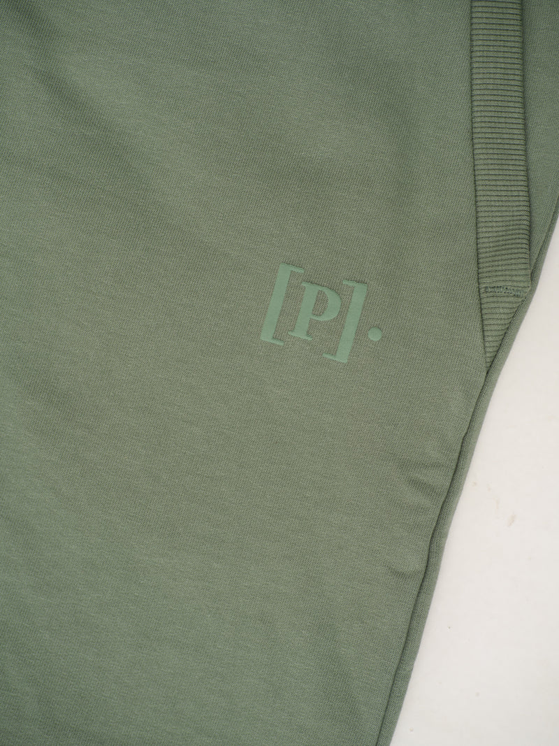 close-up view of green sweatpant by pant project with logo detail