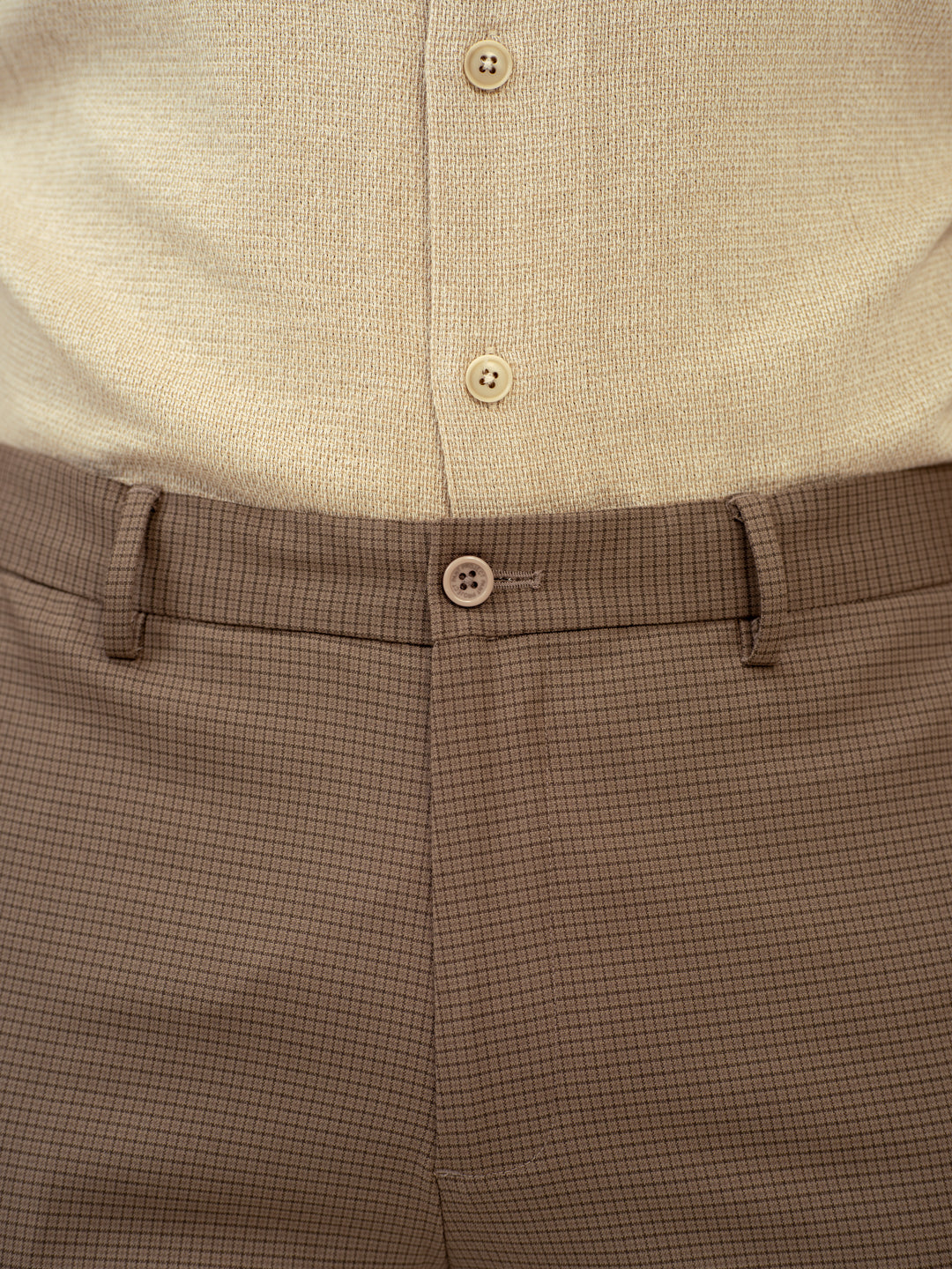 close-up view of umbre brown checkered pant by pant project highlighting button detail