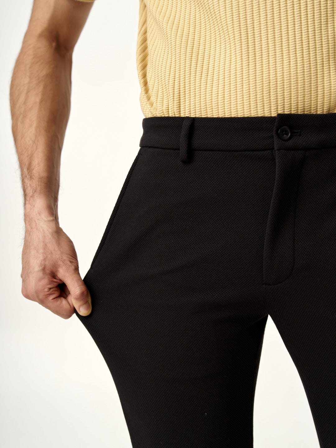 relaxed pose showcasing modern black texture pants from the Pant Project, with a denim jacket and loafers