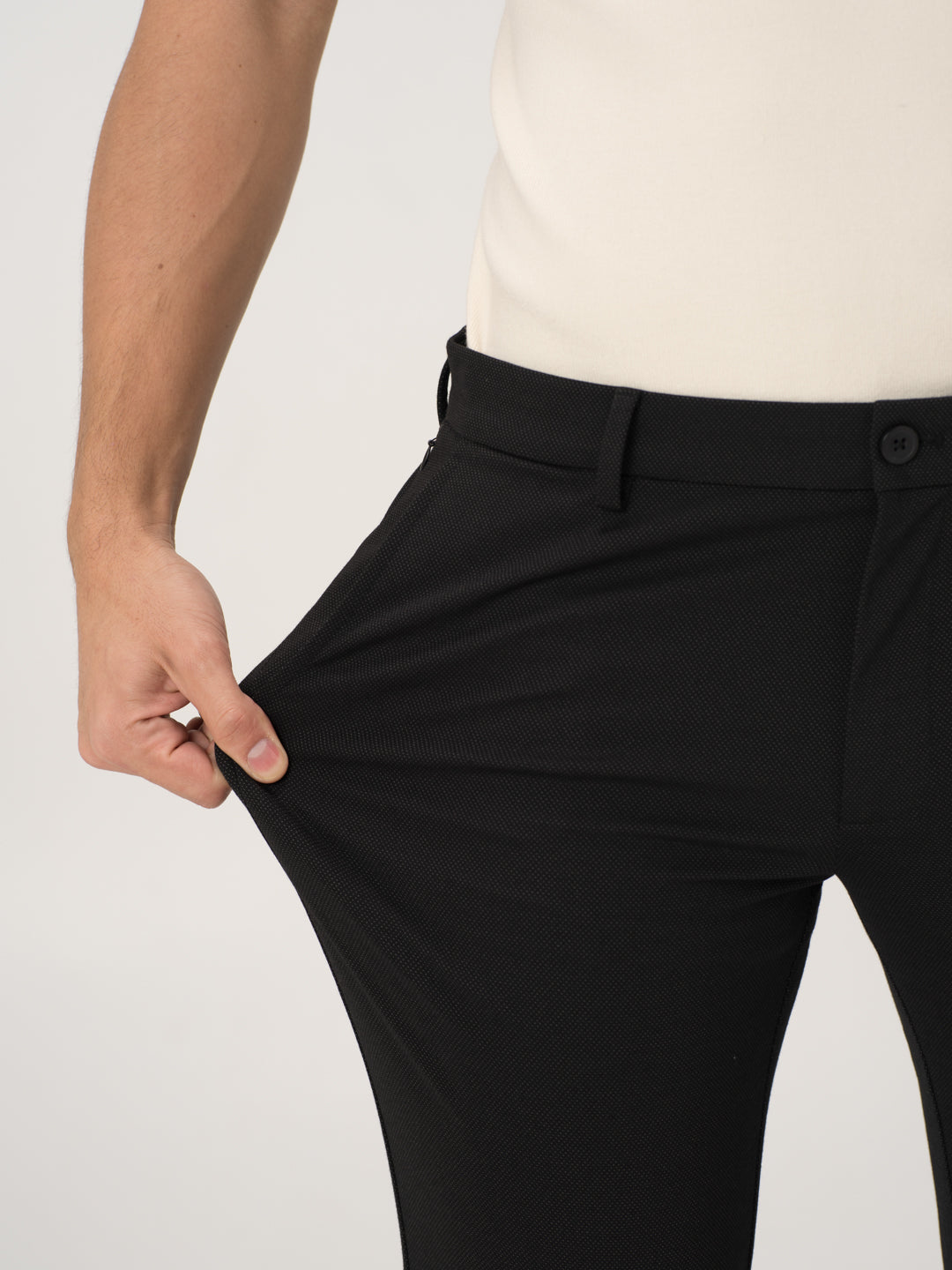 Close-up view of black stretchable trousers by pant project, focusing on the stretch of the waistband