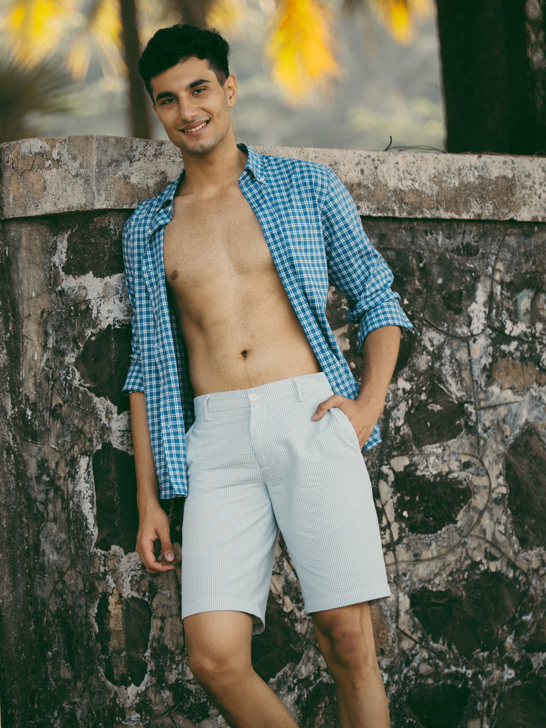 Lifestyle image of meadow green stripes seersucker chino shorts by pant project, showcasing lightweight fabric and relaxed fit in a casual outdoor setting.