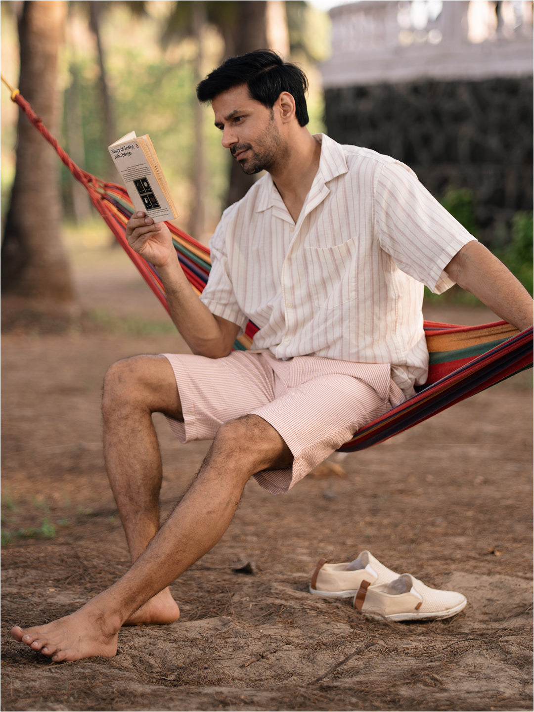 Lifestyle image of poppy peach stripes seersucker chino shorts by pant project, showcasing lightweight fabric and stylish design in a casual setting.
