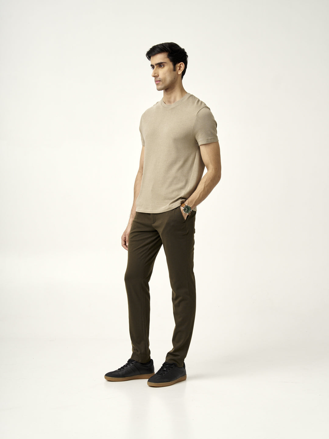 Side profile of a model wearing martini olive pants by the Pant Project with a beige shirt