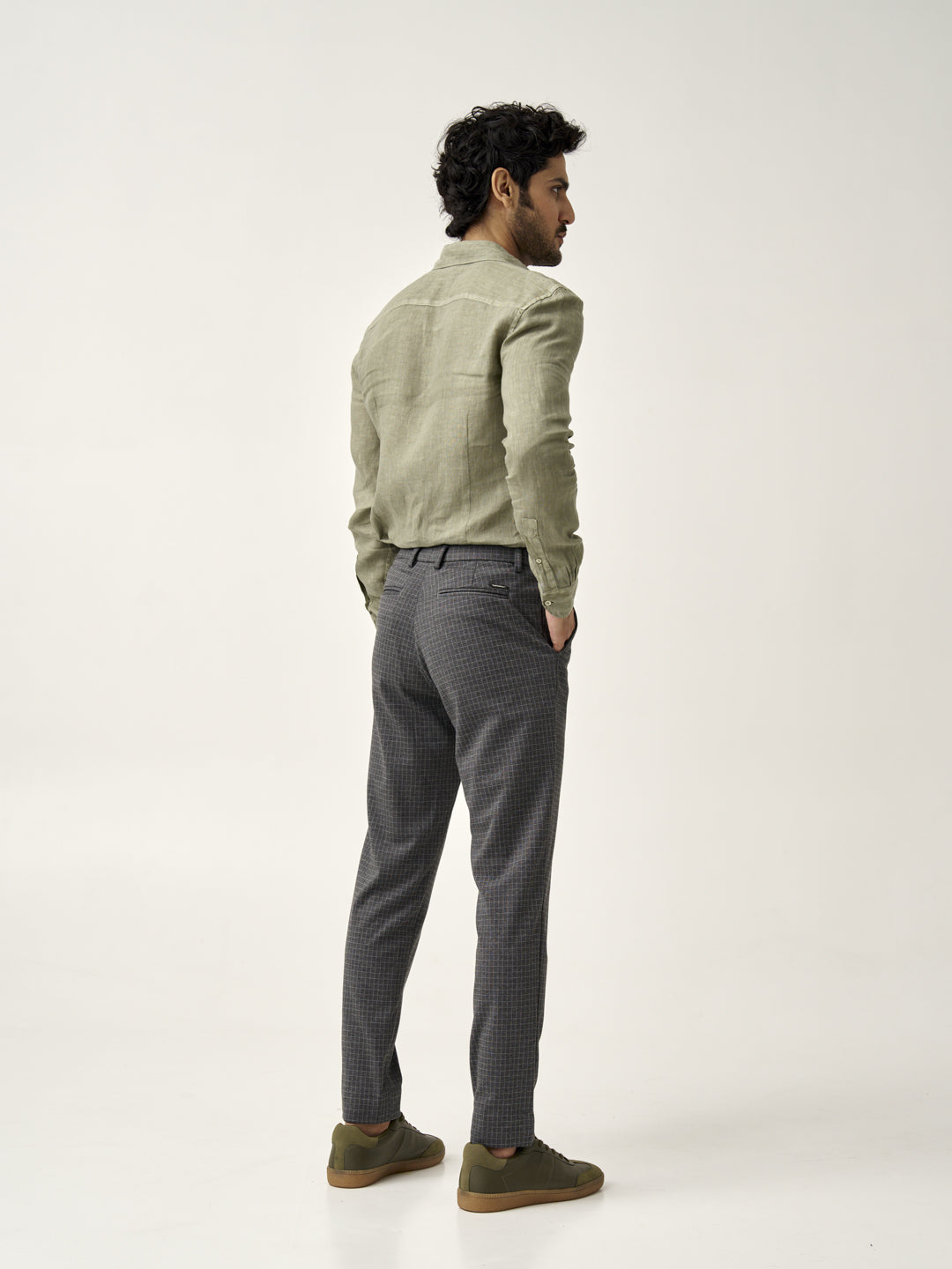 back view of a man wearing grey check pants with green shirt from the Pant Project