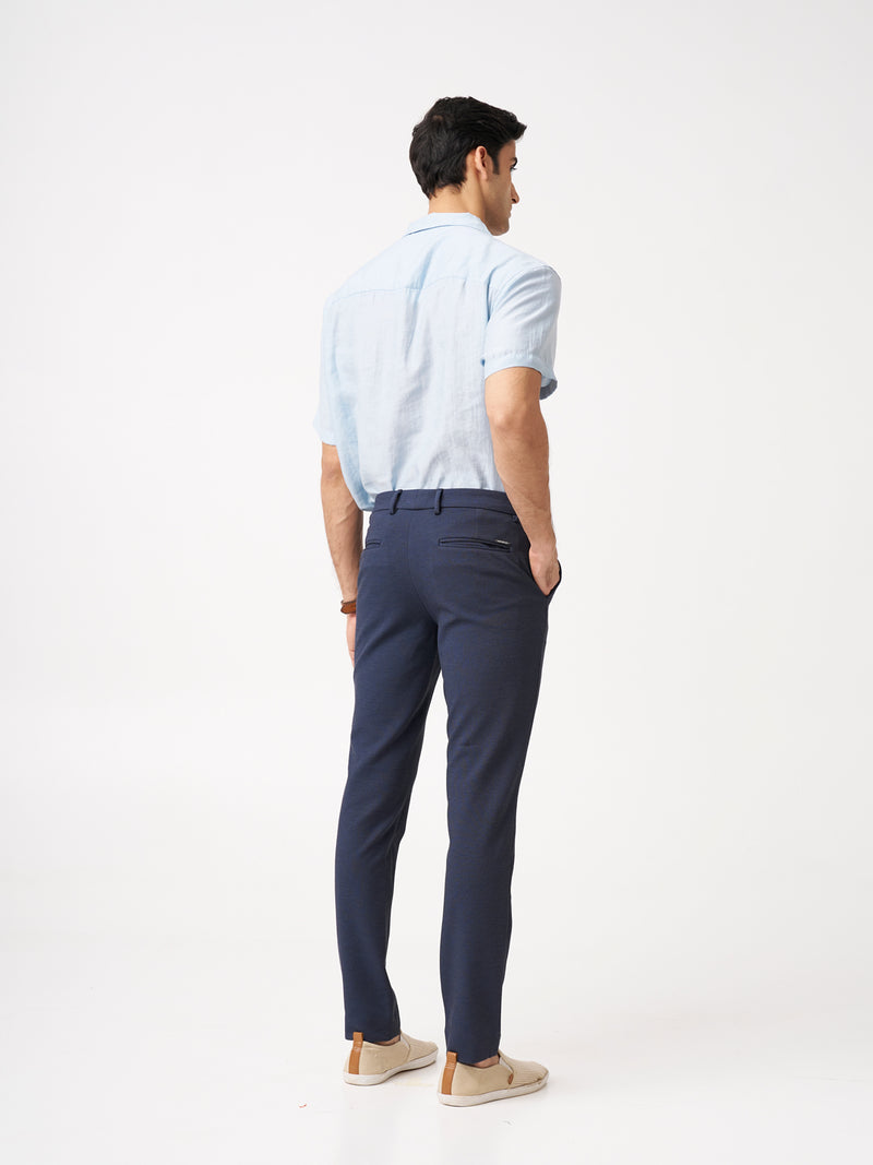 back view of man wearing the Pant Project sail blue pants with a light blue shirt
