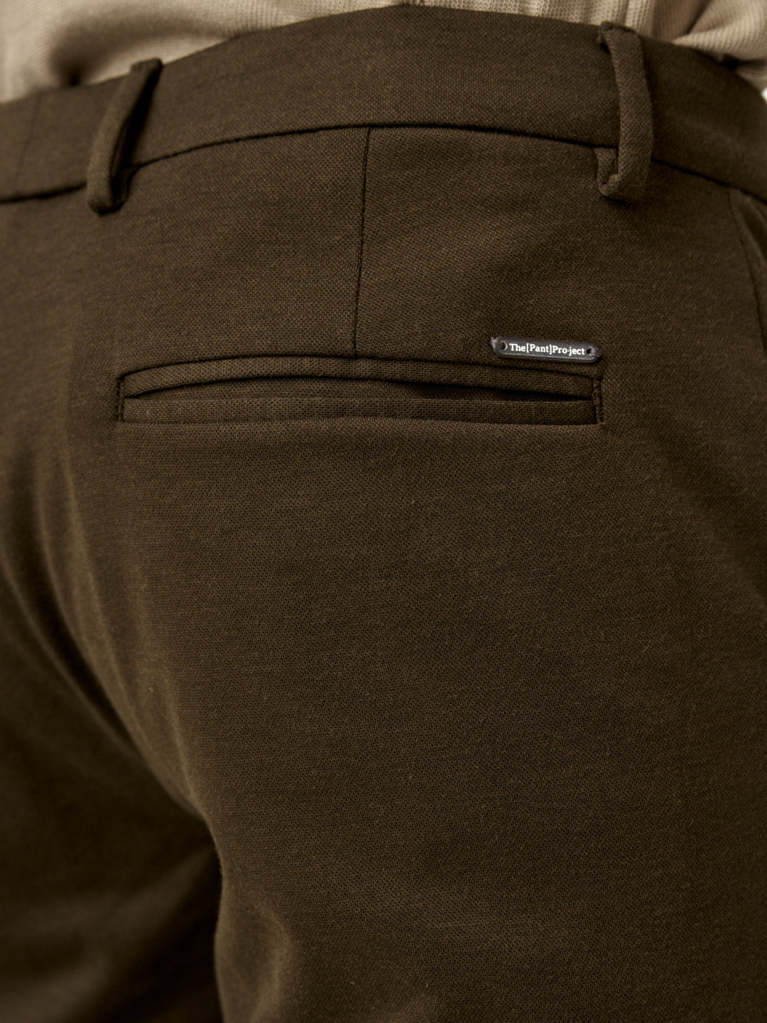 close view of martini olive pants back pocket with the Pant Project branding
