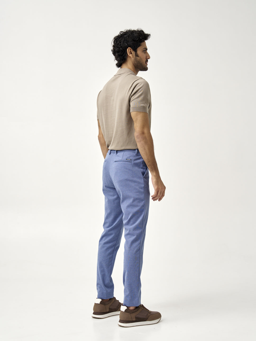 man in ocean waves pants from the Pant Project, shown from the back in a beige polo