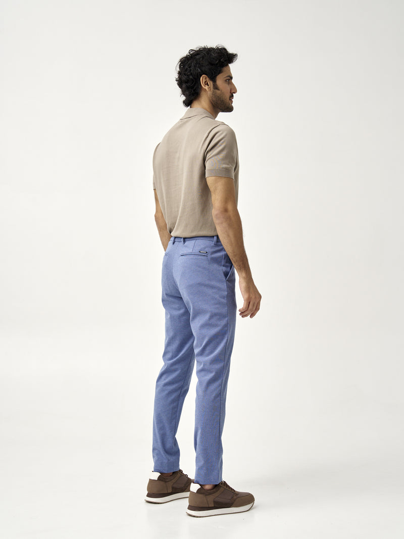 man in ocean waves pants from the Pant Project, shown from the back in a beige polo