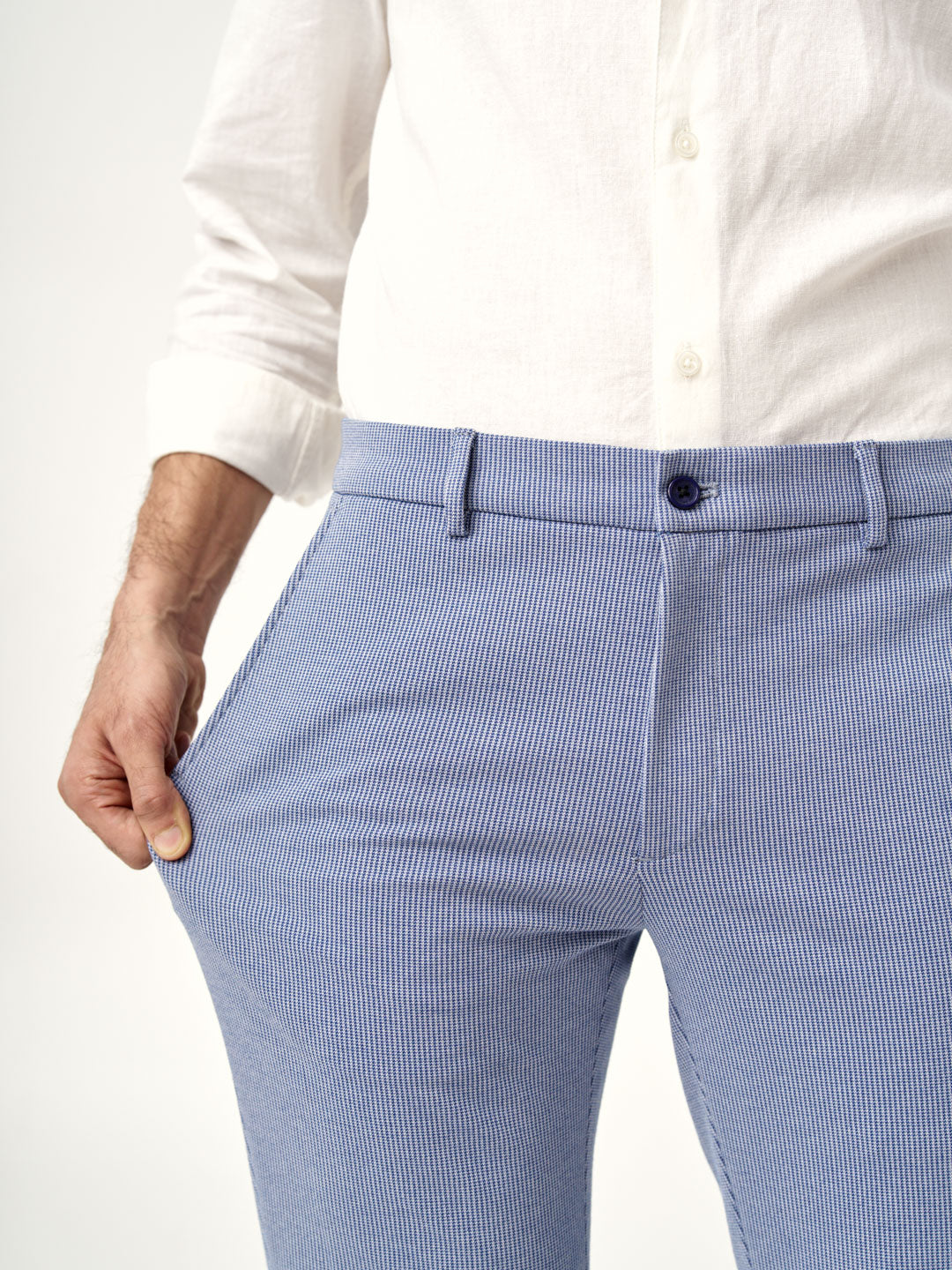 man stretching pocket of scottish blue pants by the Pant Project