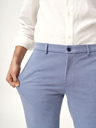 man stretching pocket of scottish blue pants by the Pant Project