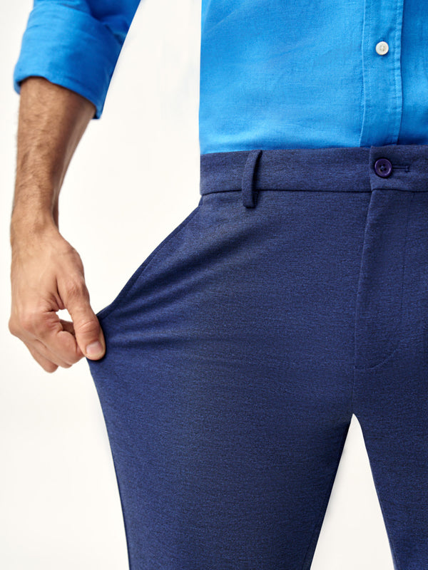 man stretching the fabric of insignia blue pants, the Pant Project