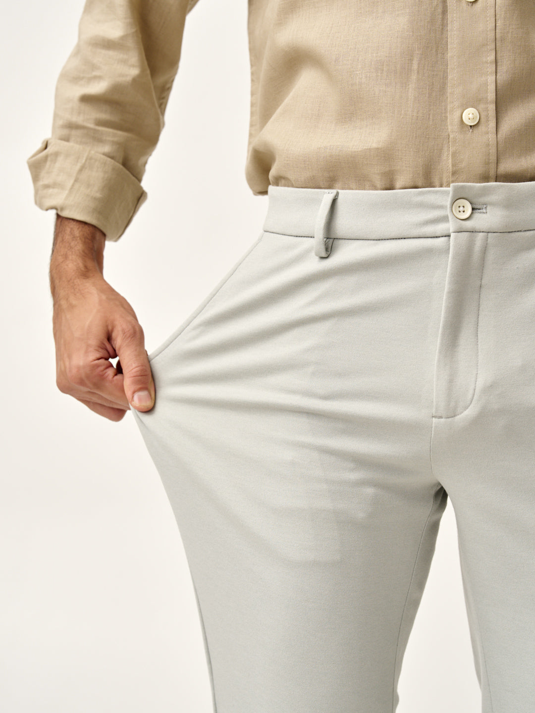 man stretching the fabric of matcha green  pants, the Pant Project