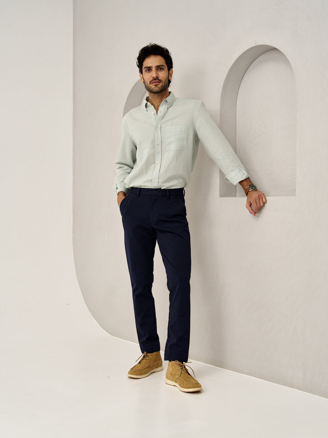 man wearing blue check pants from the Pant Project, standing against wall