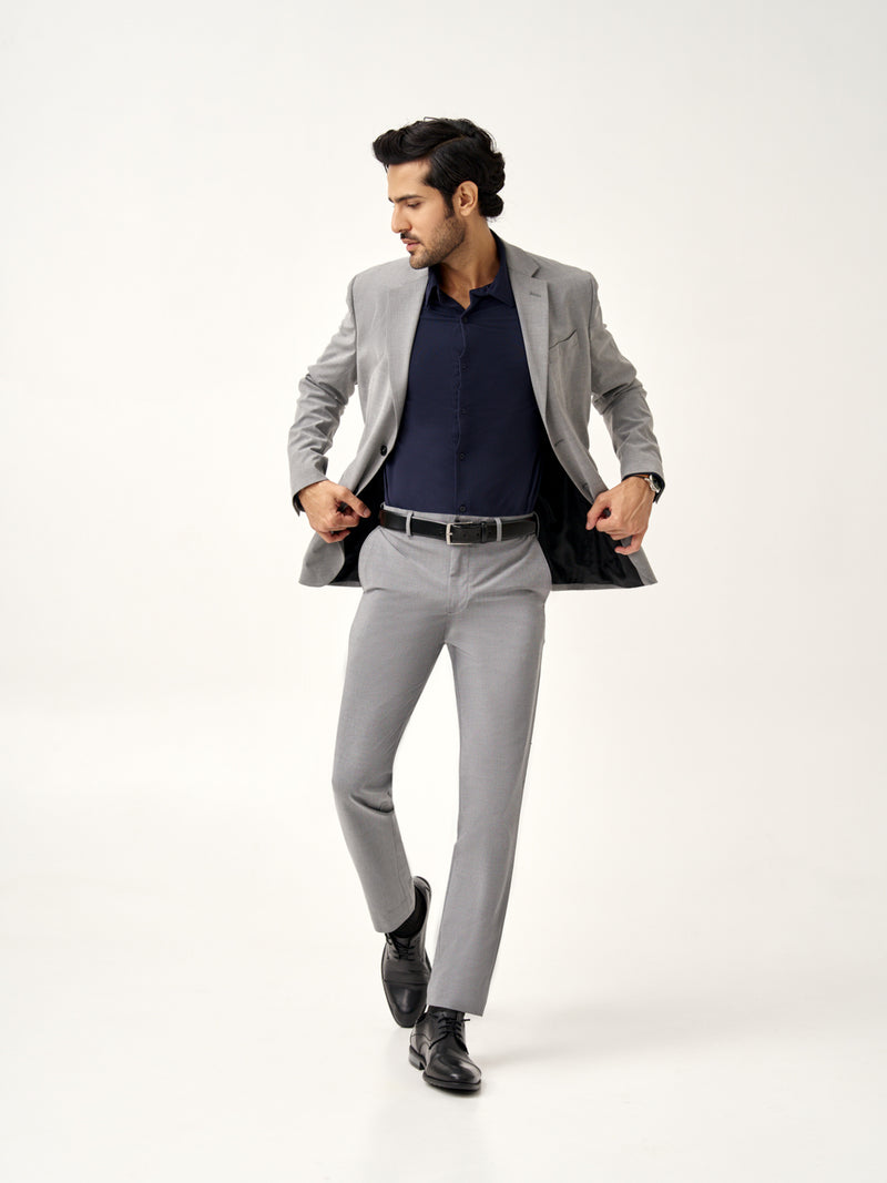 model adjusting blazer wearing Pant Project mineral grey stretchable pants