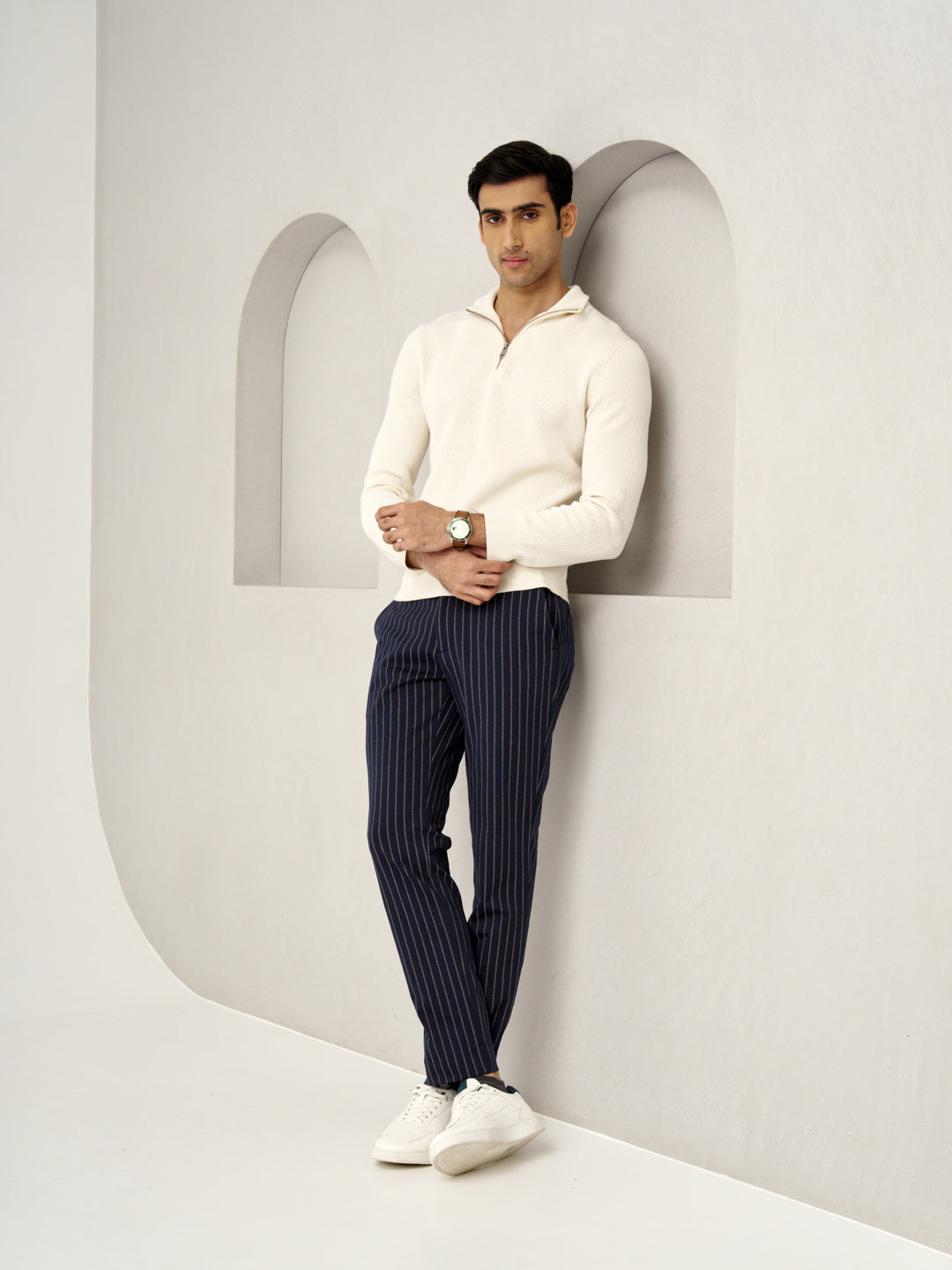 model in blue pinstripe pants by the Pant Project leaning on the wall