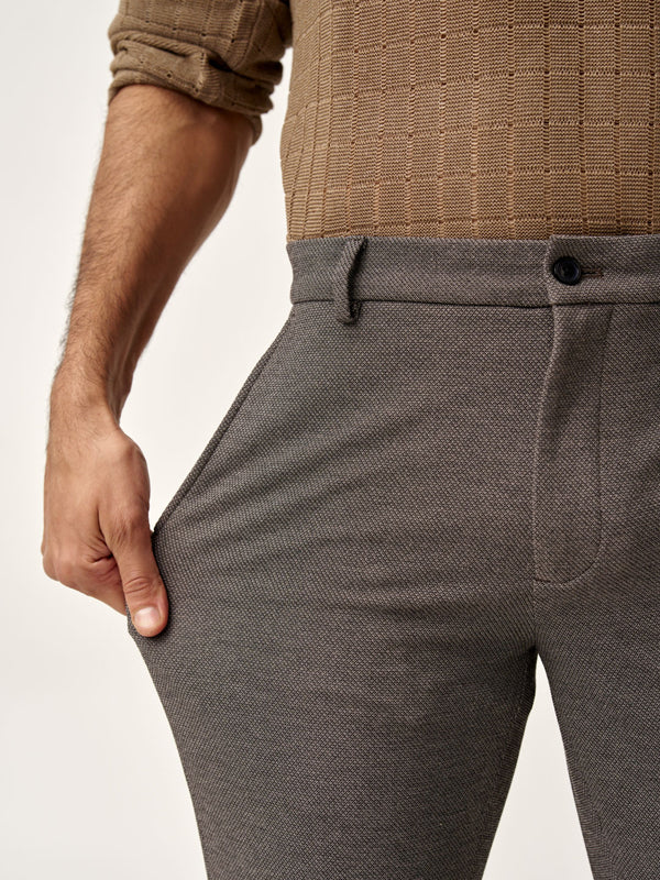model stretching the side of granite texture pants by the Pant Project