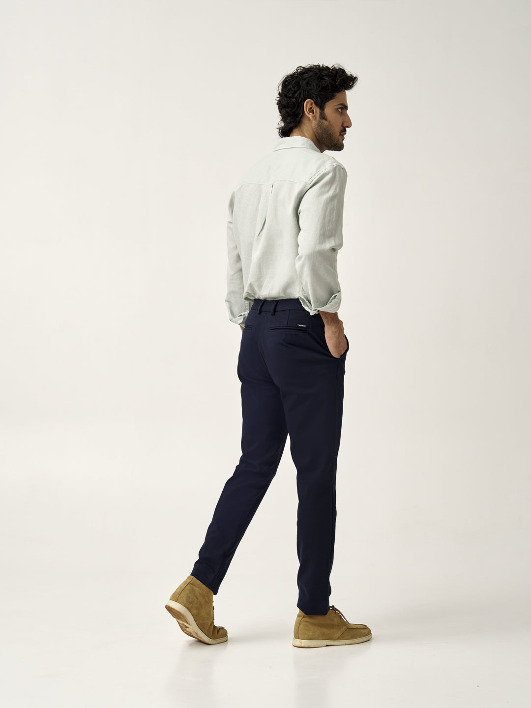 side view of man in dark navy custom pants by the Pant Project with beige shoes