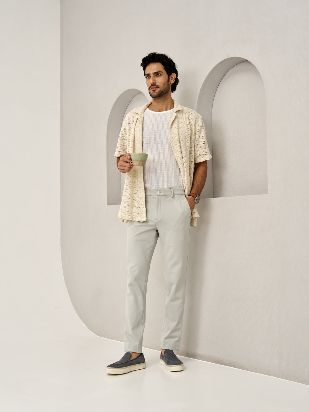 stylish man leans against a wall wearing Matcha Green pants by the Pant Project