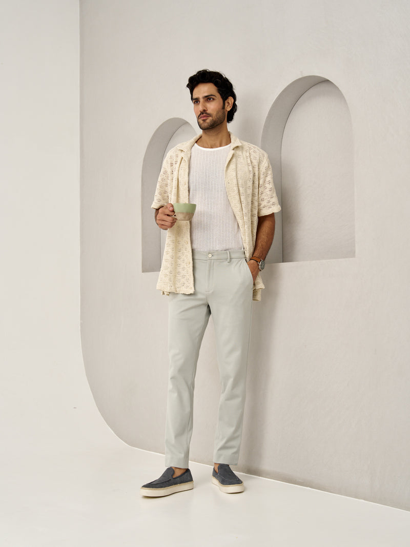 stylish man leans against a wall wearing Matcha Green pants by the Pant Project