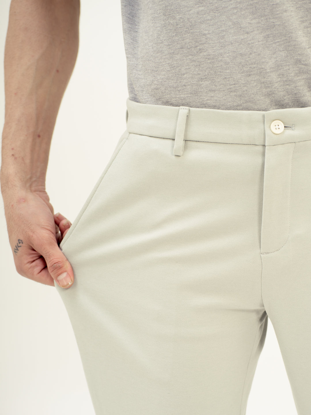 Close-up view of green stretchable trousers by pant project, focusing on the stretch of the fabric at the waistband