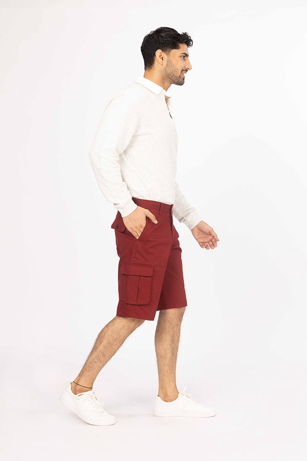 side view of red cargo shorts by pant project with pocket detail